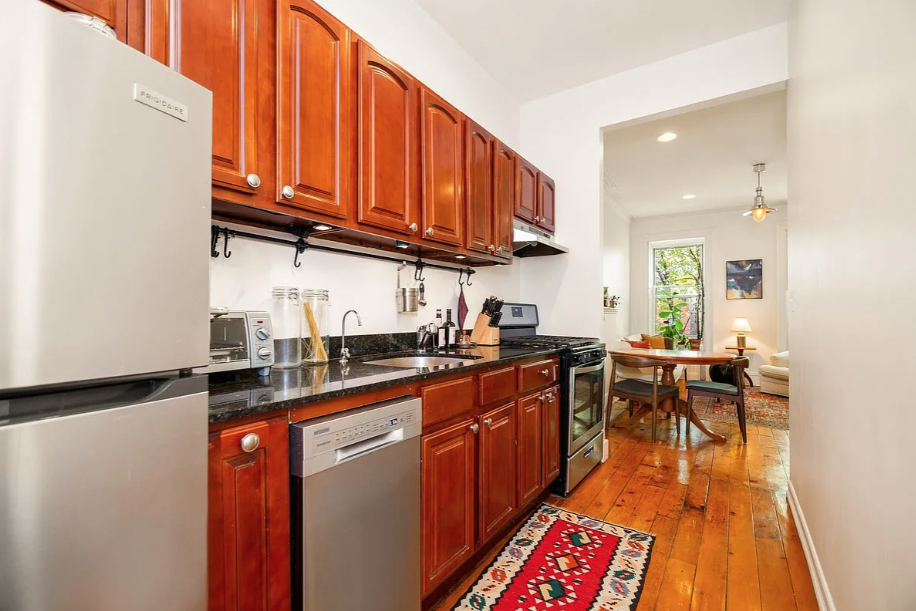 464 Macon Street, Unit 2 Brooklyn, NY 11233 - Photo 3 of 9 a kitchen with stainless steel appliances granite countertop a sink a stove cabinets counter space and a window