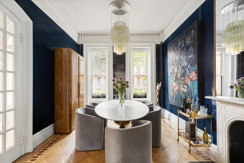 a dining room with chandelier and wooden floor