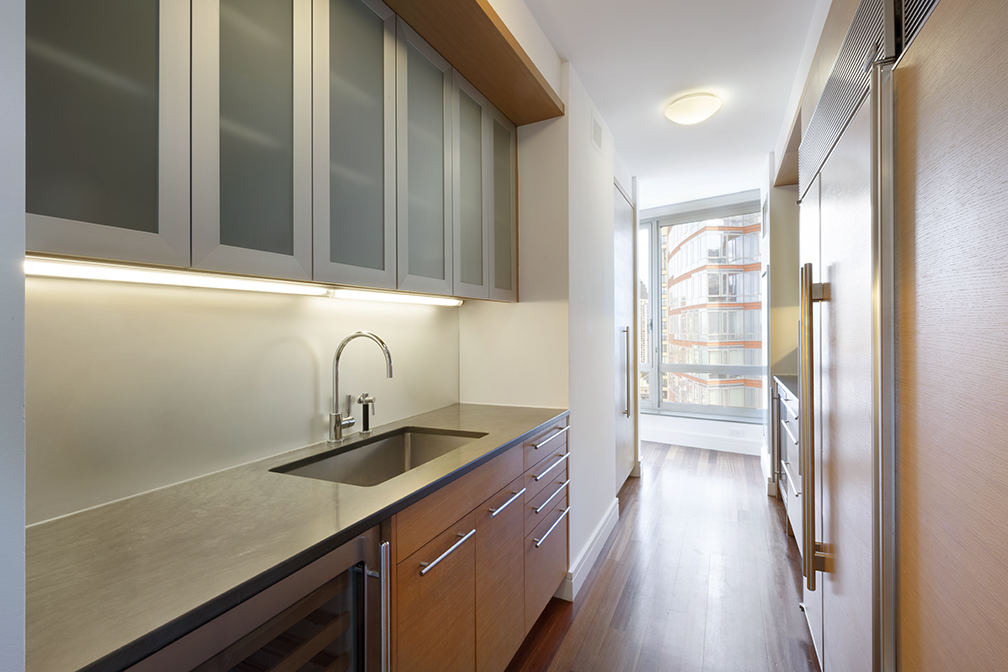 30 West Street, Unit 21AB Manhattan, NY 10004 - Photo 14 of 17 a kitchen with stainless steel appliances granite countertop a sink and a refrigerator