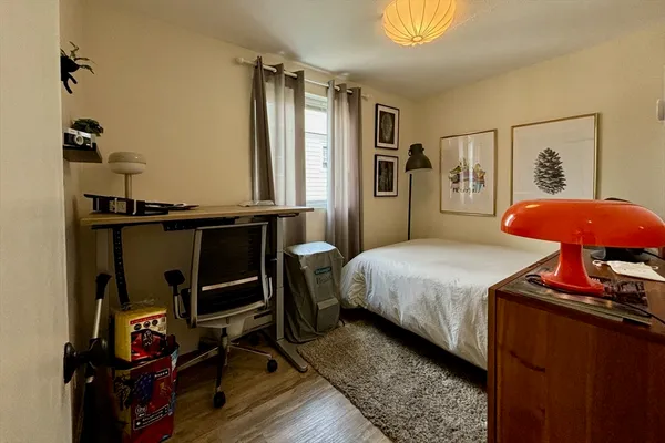 a bedroom with a bed and wooden floor