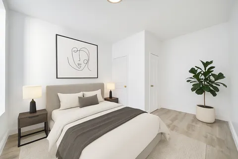 a bedroom with a bed and a potted plant