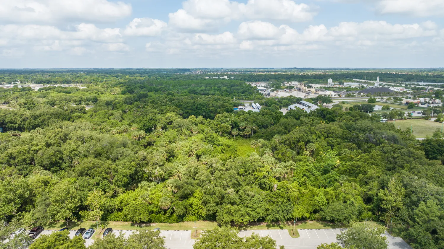 an aerial view of residential houses with outdoor space and trees