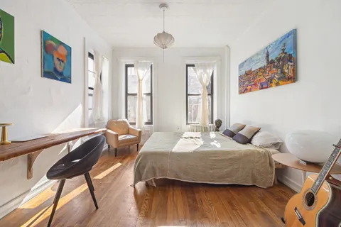 a bedroom with a bed and wooden floor