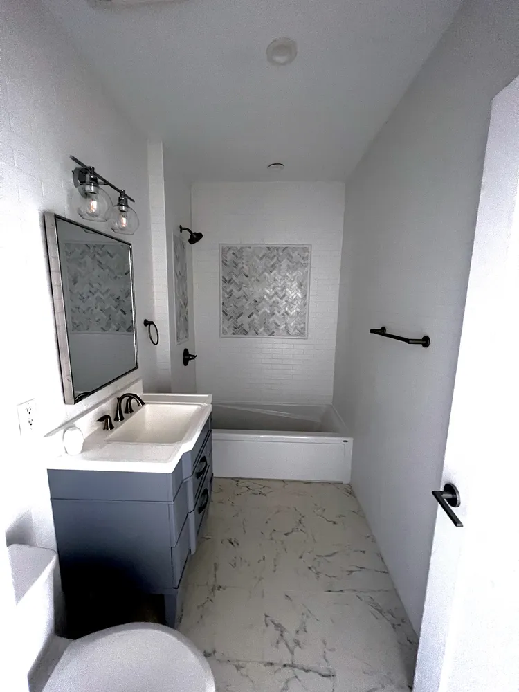 a bathroom with a sink toilet tub and mirror