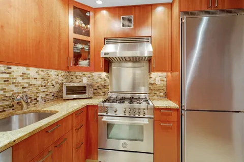 a kitchen with stainless steel appliances granite countertop a refrigerator and a sink