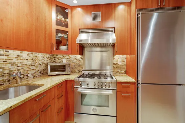 a kitchen with stainless steel appliances granite countertop a refrigerator and a sink