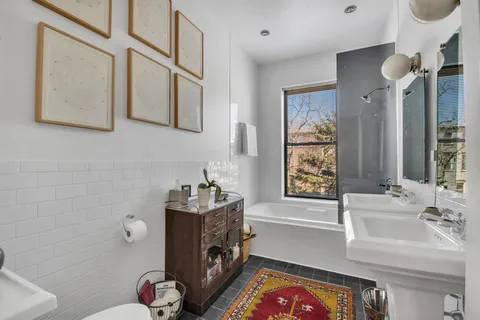 a bathroom with a sink a bathtub and a window
