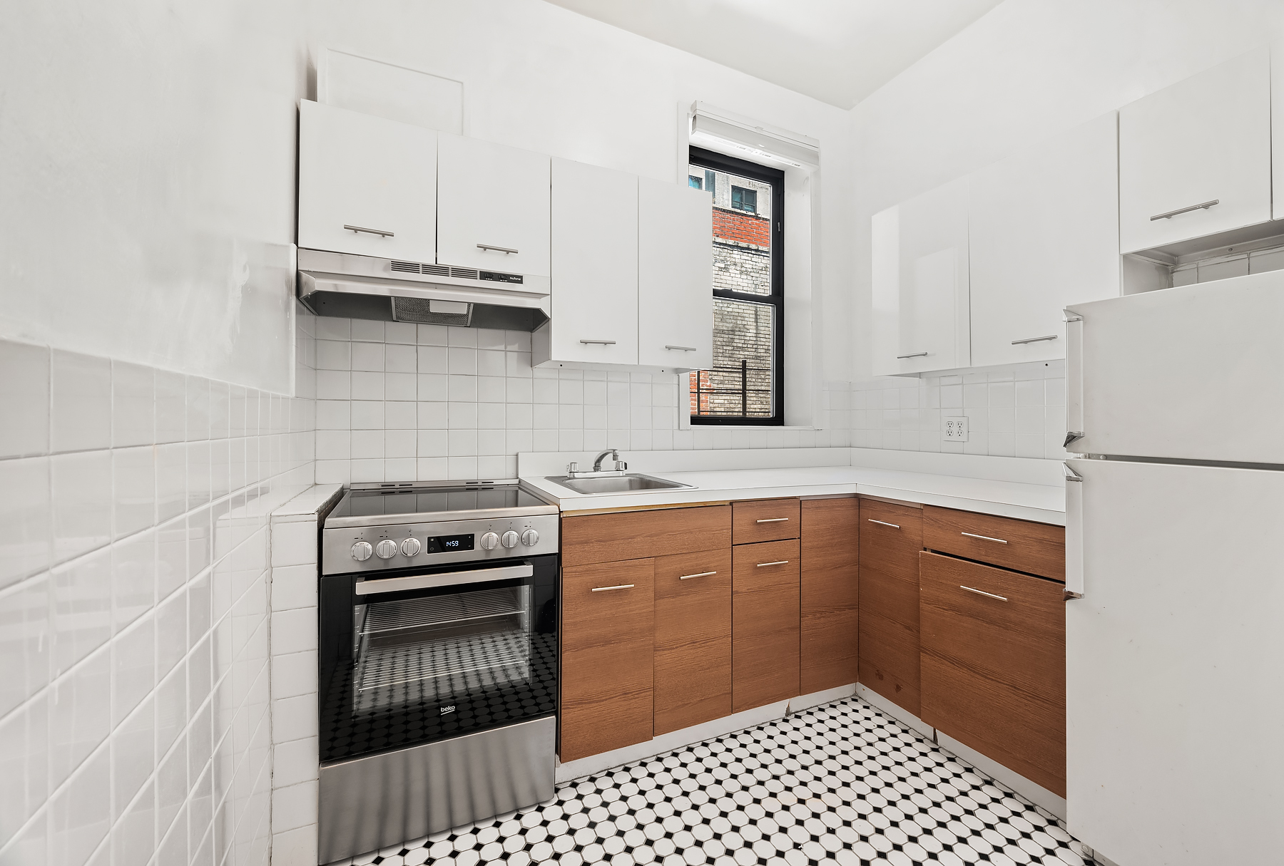 862 West End Avenue, Unit 2R Manhattan, NY 10025 - Photo 5 of 8 a kitchen with granite countertop a stove top oven cabinets and a refrigerator