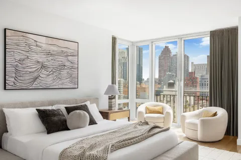 a bedroom with a large bed and glass window