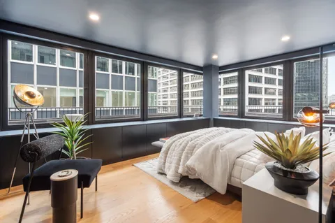 a bedroom with a bed and a large window