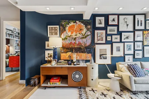 a living room with furniture a rug and white walls