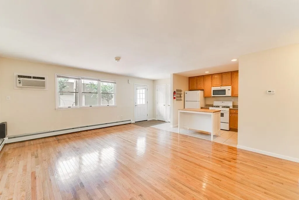 a view of a kitchen with wooden floor and a refrigerator