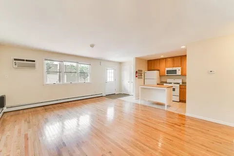 a view of a kitchen with wooden floor and a refrigerator