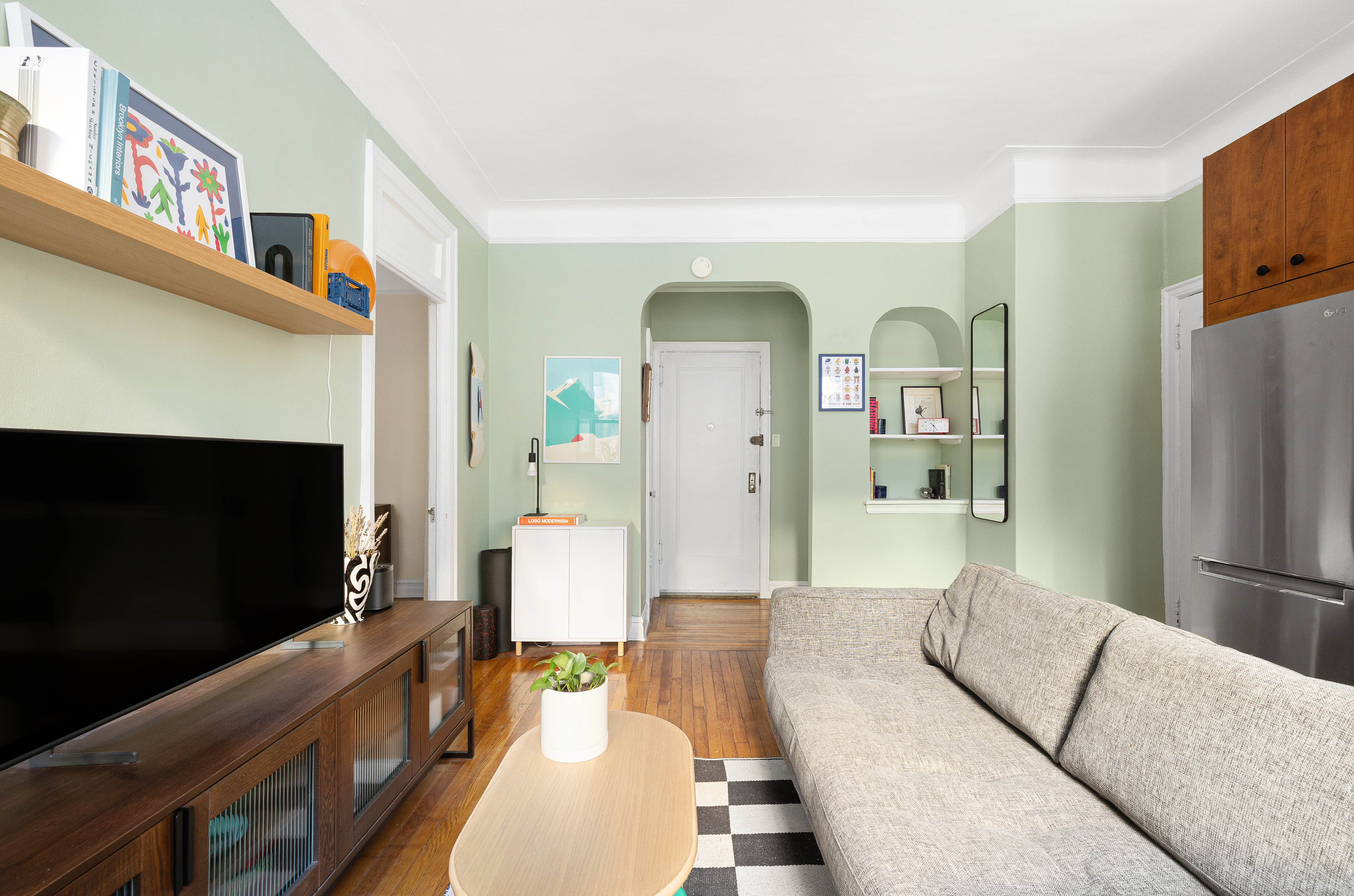 78 8th Avenue, Unit 2K Brooklyn, NY 11215 - Photo 3 of 10 a living room with furniture a flat screen tv and a fireplace
