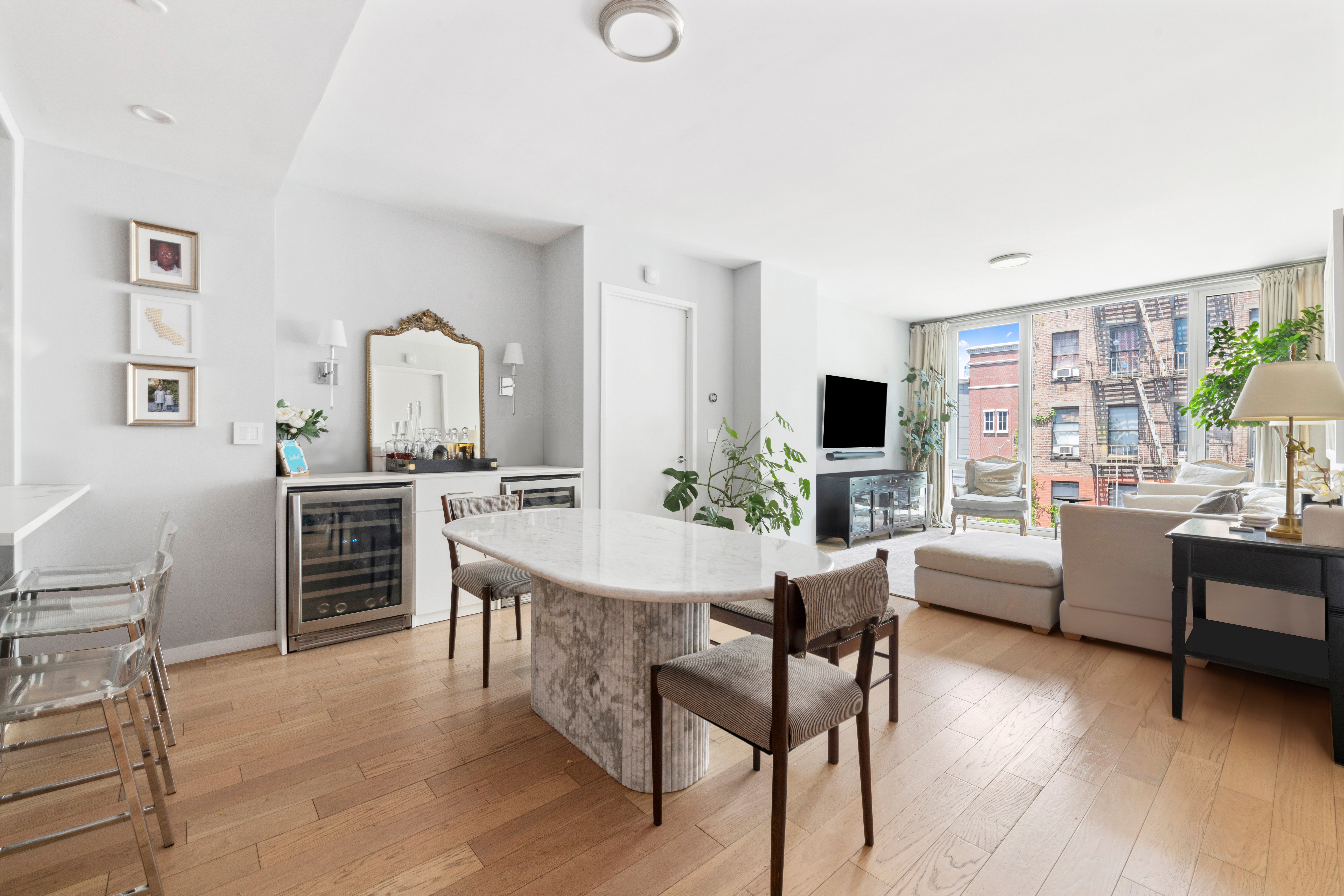 540 West 49th Street, Unit 401S Manhattan, NY 10019 - Photo 3 of 14 a living room with furniture a flat screen tv and kitchen view