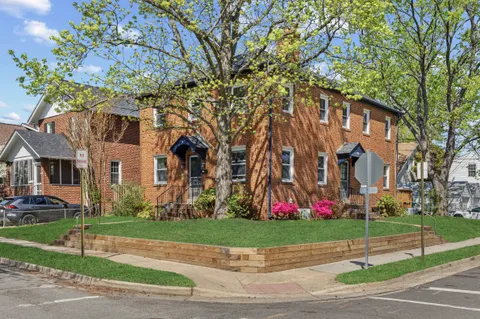 a view of a white house with a yard and plants