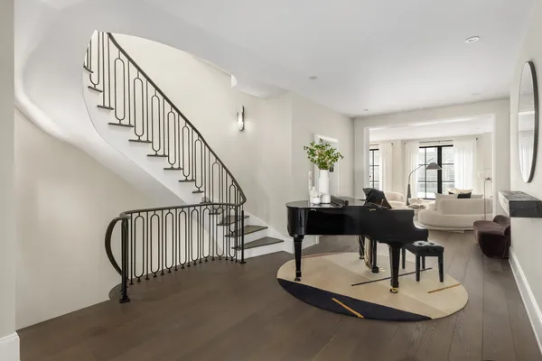 a living room with couches coffee table and a dining table with wooden floor