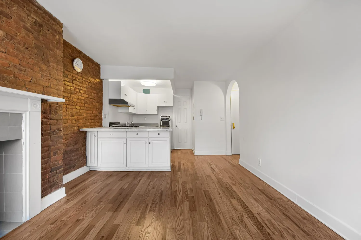 a kitchen with wooden floors and white cabinets