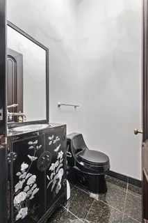 a bathroom with a toilet and mirror