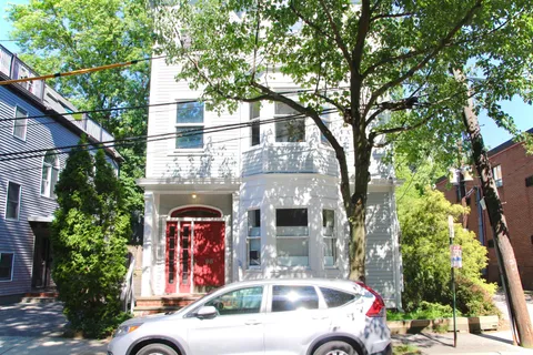 a front view of a house with plants and trees