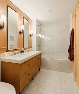 a bathroom with a sink double vanity mirror and a bathtub