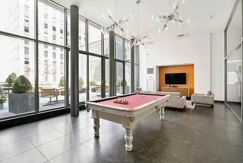 a room with pool table and windows
