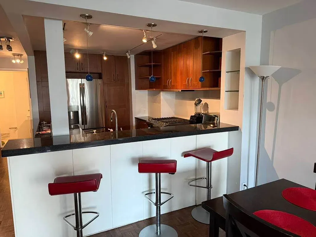a kitchen with stainless steel appliances granite countertop a sink and a refrigerator