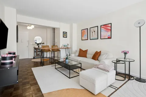 a living room with furniture and wooden floor