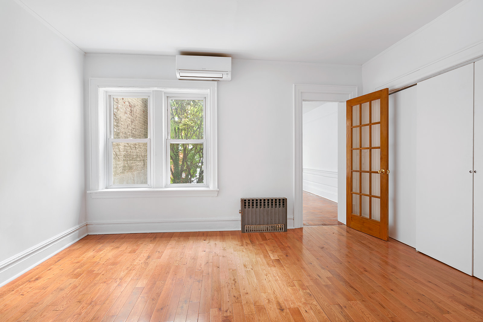 165 Fenimore Street Brooklyn, NY 11225 - Photo 9 of 13 an empty room with wooden floor and windows