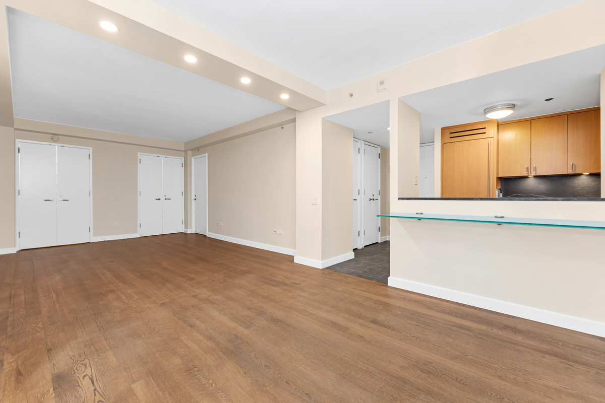 100 West 58th Street, Unit 12A Manhattan, NY 10019 - Photo 8 of 15 a view of empty room with wooden floor