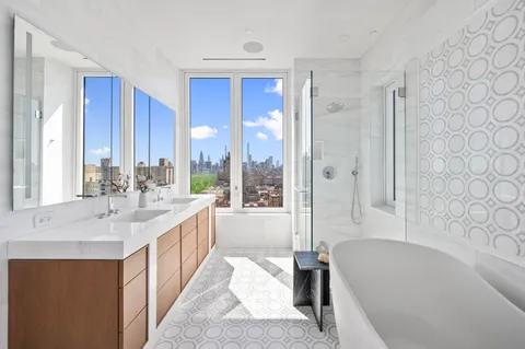 a bathroom with a double vanity sink a mirror and a bathtub