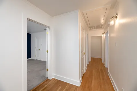 a view of a hallway with wooden floor