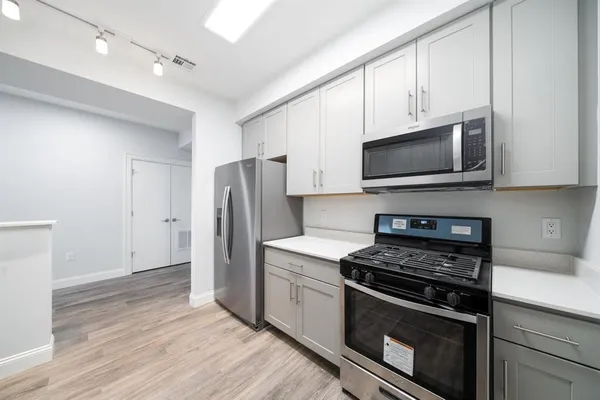 a kitchen with stainless steel appliances a stove microwave and refrigerator