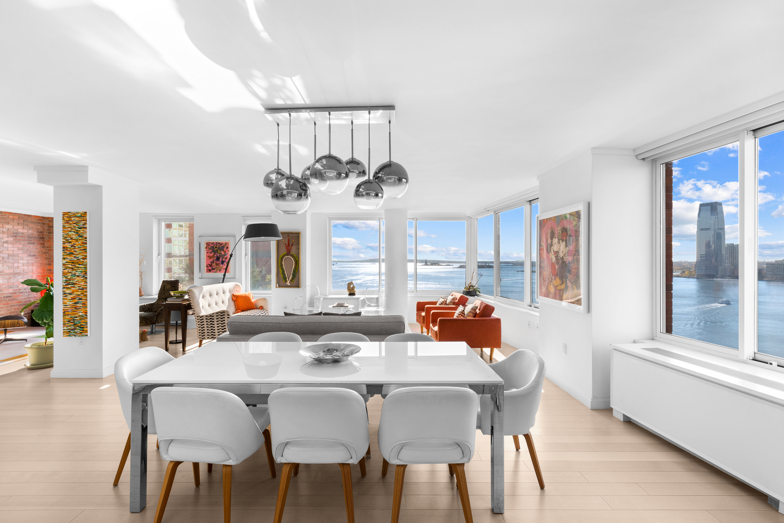 212 Warren Street, Unit 20A Manhattan, NY 10282 - Photo 3 of 23 a view of a dining room with furniture a chandelier and wooden floor