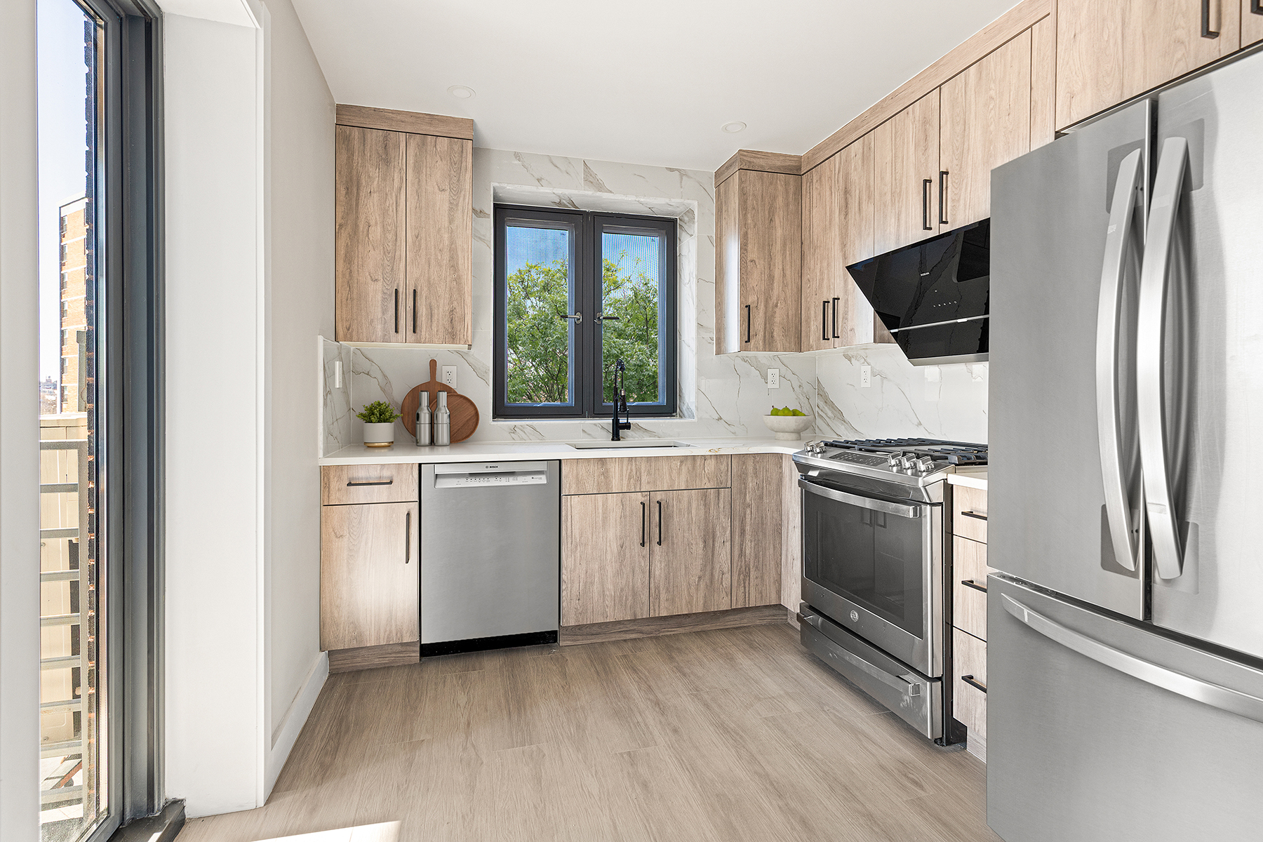 1546 Broadway, Unit 4B Brooklyn, NY 11233 - Photo 4 of 6 a kitchen with white cabinets and stainless steel appliances