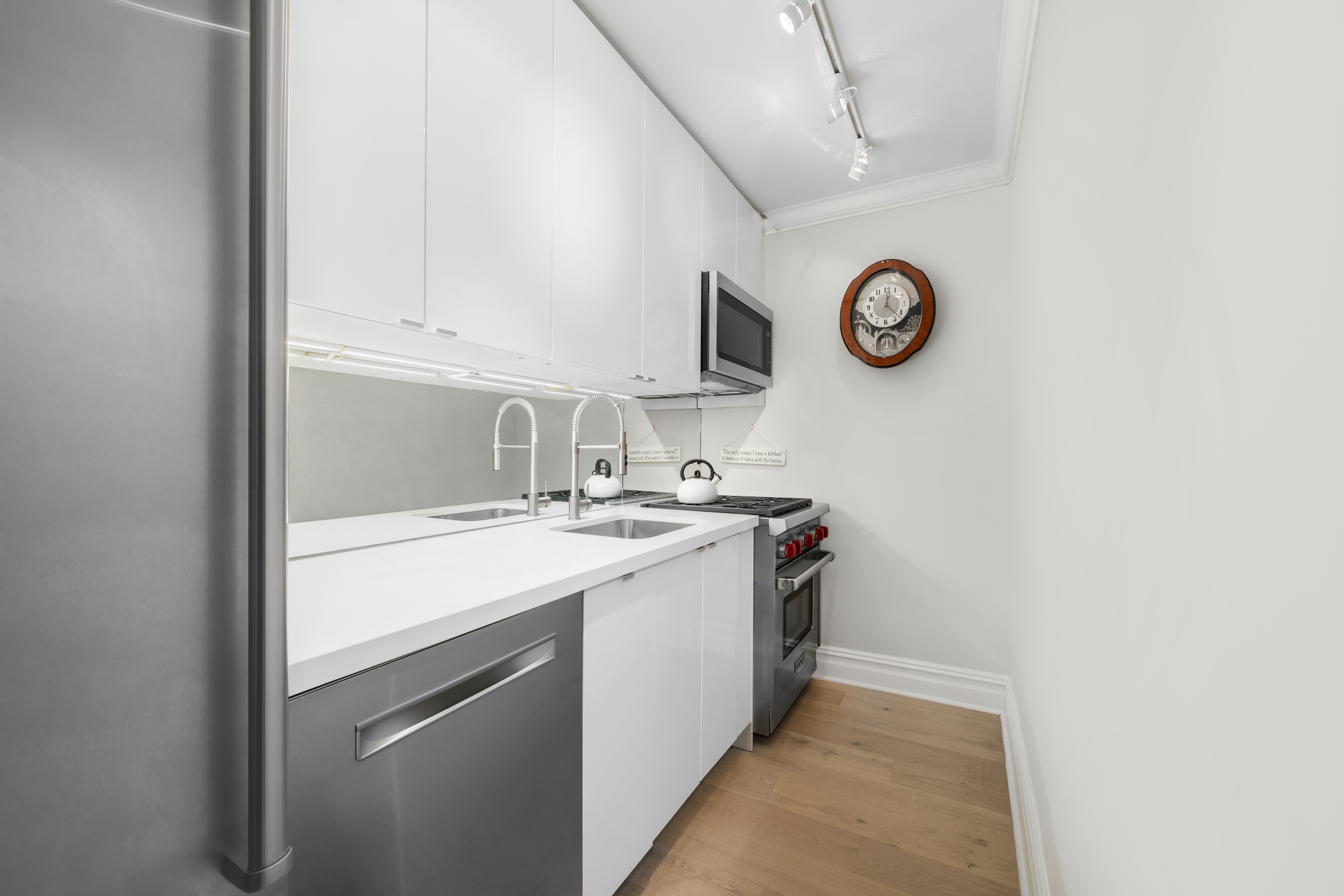 77 West 55th Street, Unit 9F Manhattan, NY 10019 - Photo 8 of 11 a kitchen with a sink and a stove