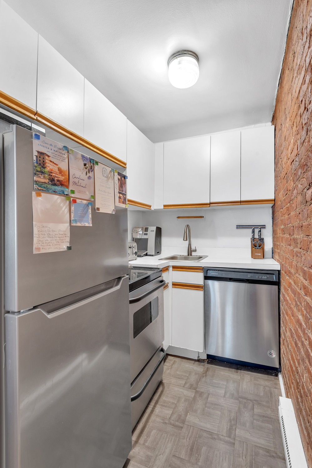 220 West 15th Street, Unit 1A Manhattan, NY 10011 - Photo 4 of 6 a kitchen with stainless steel appliances granite countertop a sink and a refrigerator
