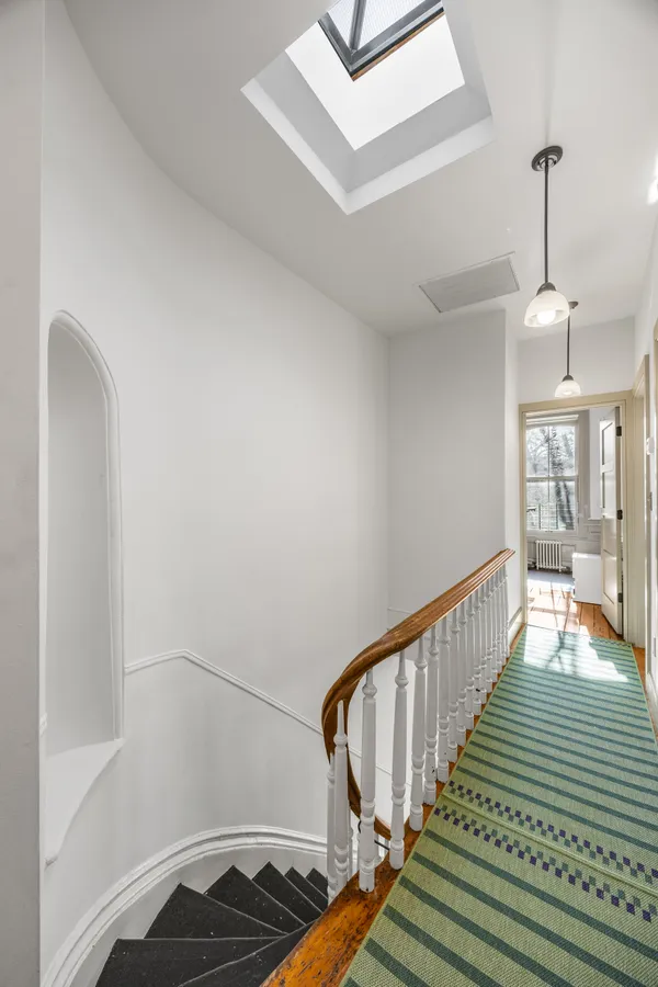 a view of entryway and hall with wooden floor
