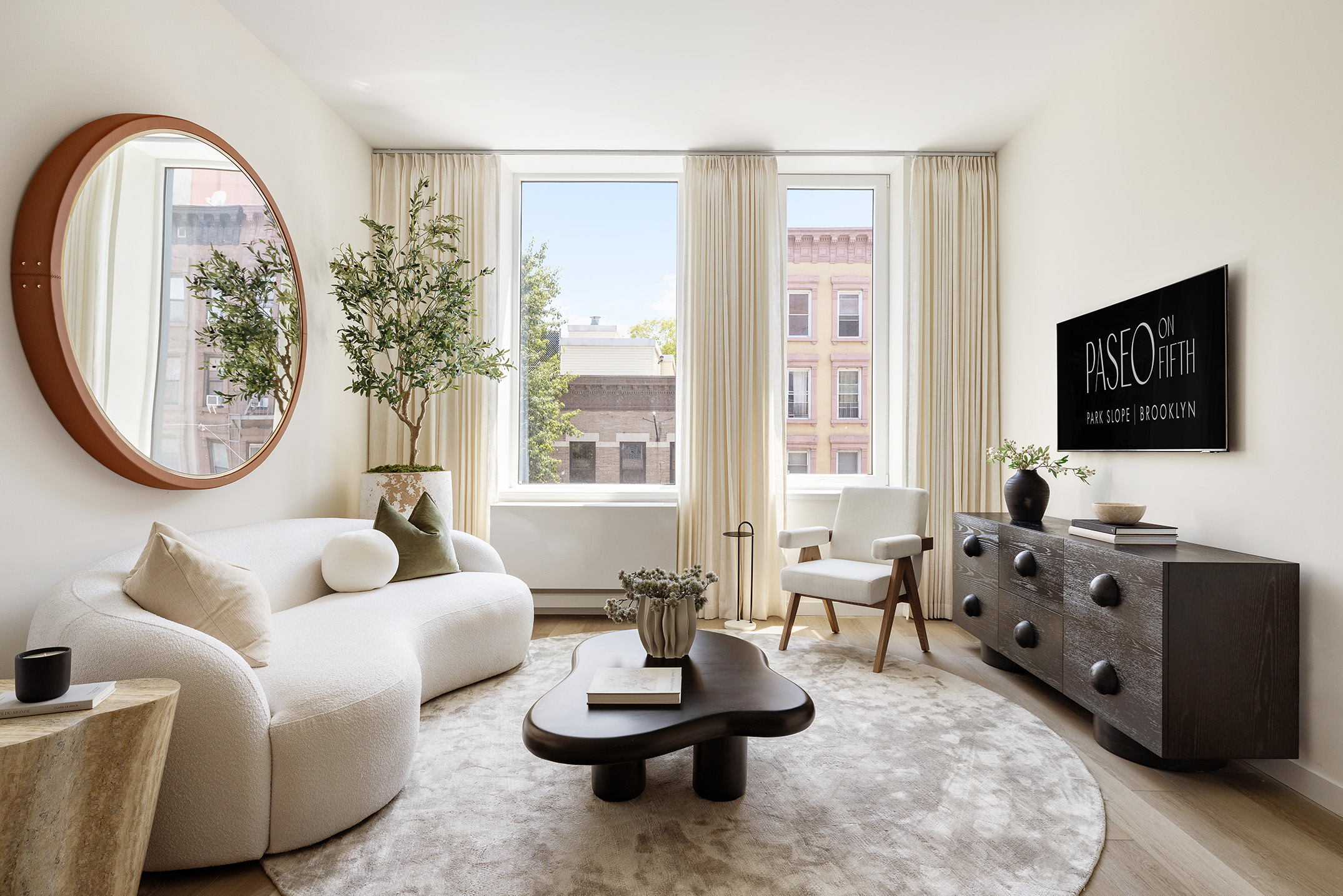 55 Paseo Place, Unit 410 Brooklyn, NY 11217 - Photo 7 of 9 a living room with furniture a flat screen tv and a large window