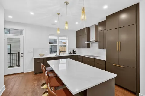 a kitchen with kitchen island a large counter top space and stainless steel appliances