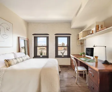 a bedroom with a bed and a desk