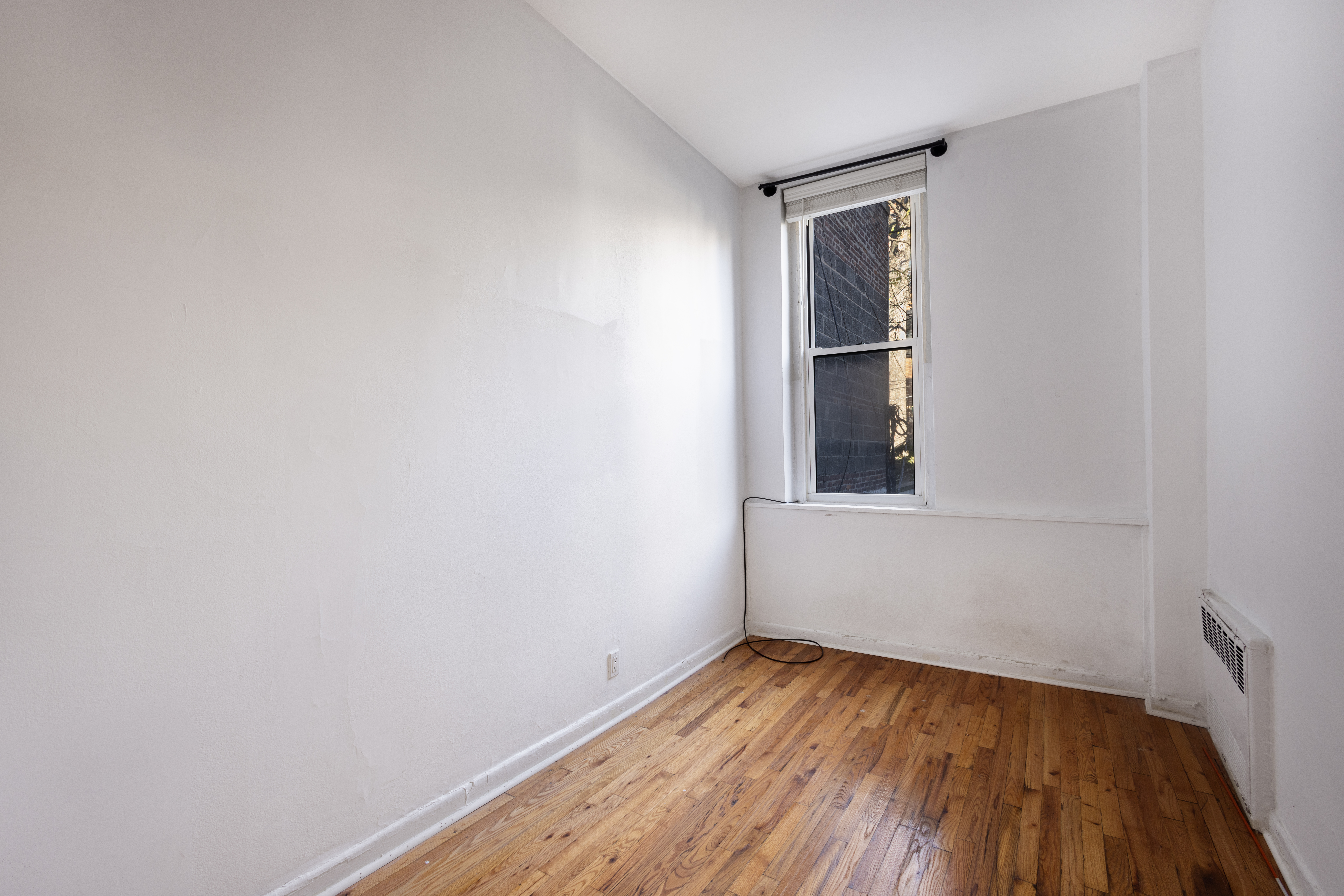 145 State Street, Unit 1 Brooklyn, NY 11201 - Photo 6 of 12 a view of an empty room with wooden floor and a window