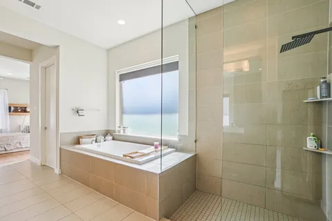 a bathroom with a tub a sink and mirror