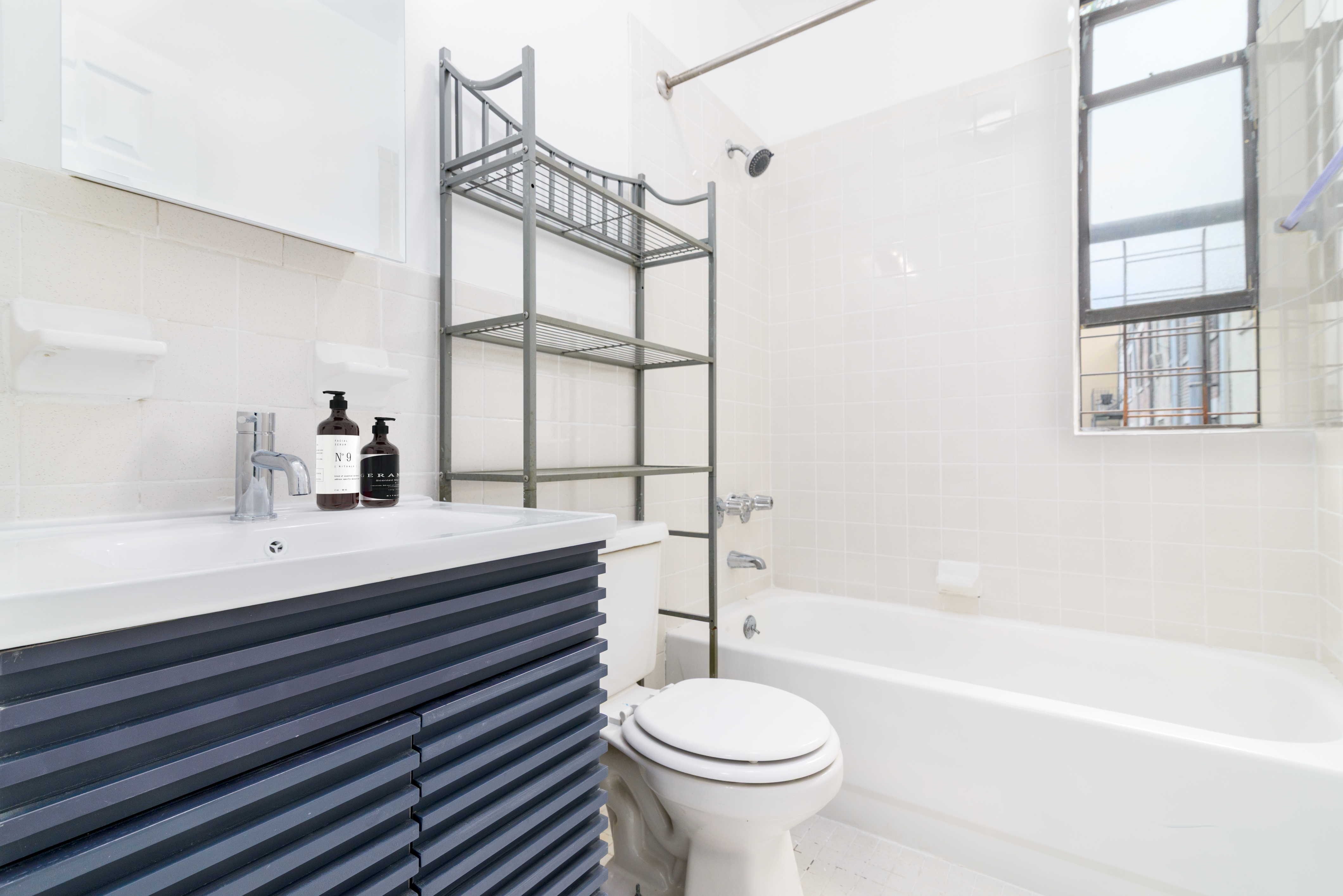517 West 144th Street, Unit 9 Manhattan, NY 10031 - Photo 18 of 22 a bathroom with a sink toilet a mirror and bathtub