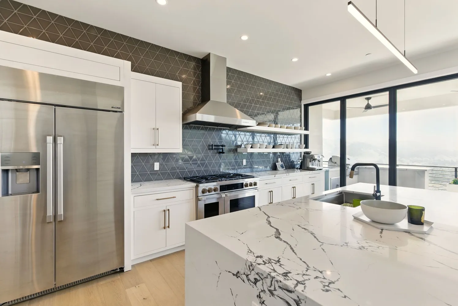 a kitchen with stainless steel appliances kitchen island granite countertop a stove a refrigerator and a sink with granite countertops