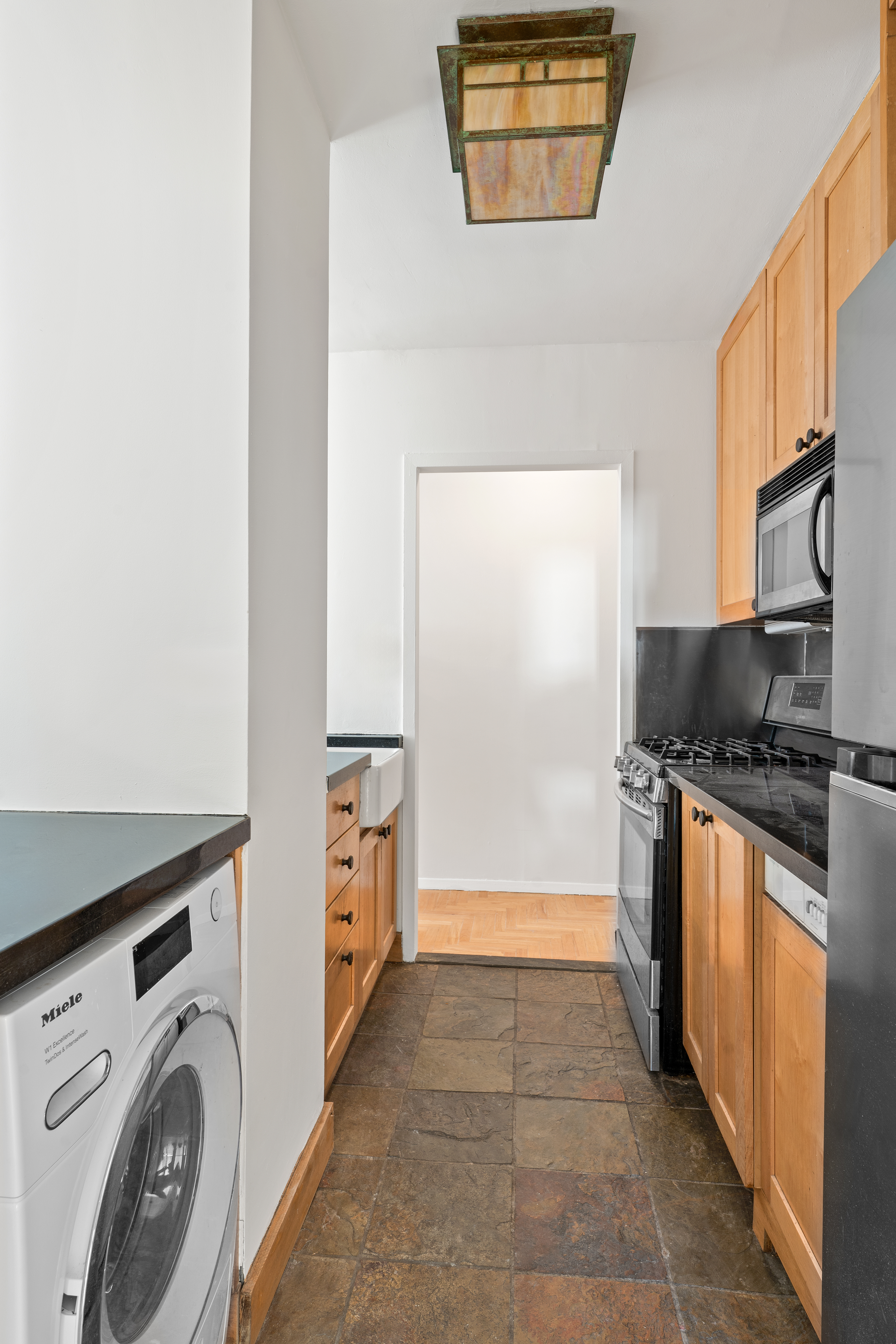 343 East 74th Street, Unit 7L Manhattan, NY 10021 - Photo 5 of 11 a kitchen with granite countertop white cabinets and stainless steel appliances