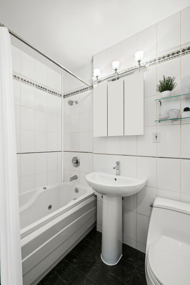 155 East 34th Street, Unit 6O Manhattan, NY 10016 - Photo 4 of 6 a bathroom with a sink a toilet and shower