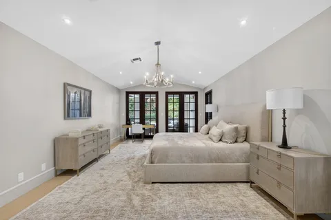 a spacious bedroom with a bed and a chandelier