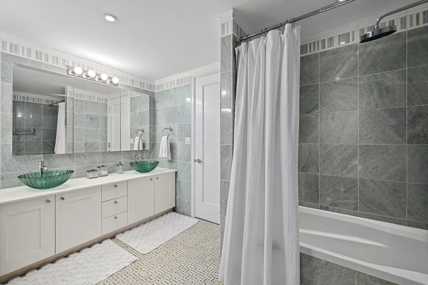 a bathroom with a double vanity sink and mirror with shower
