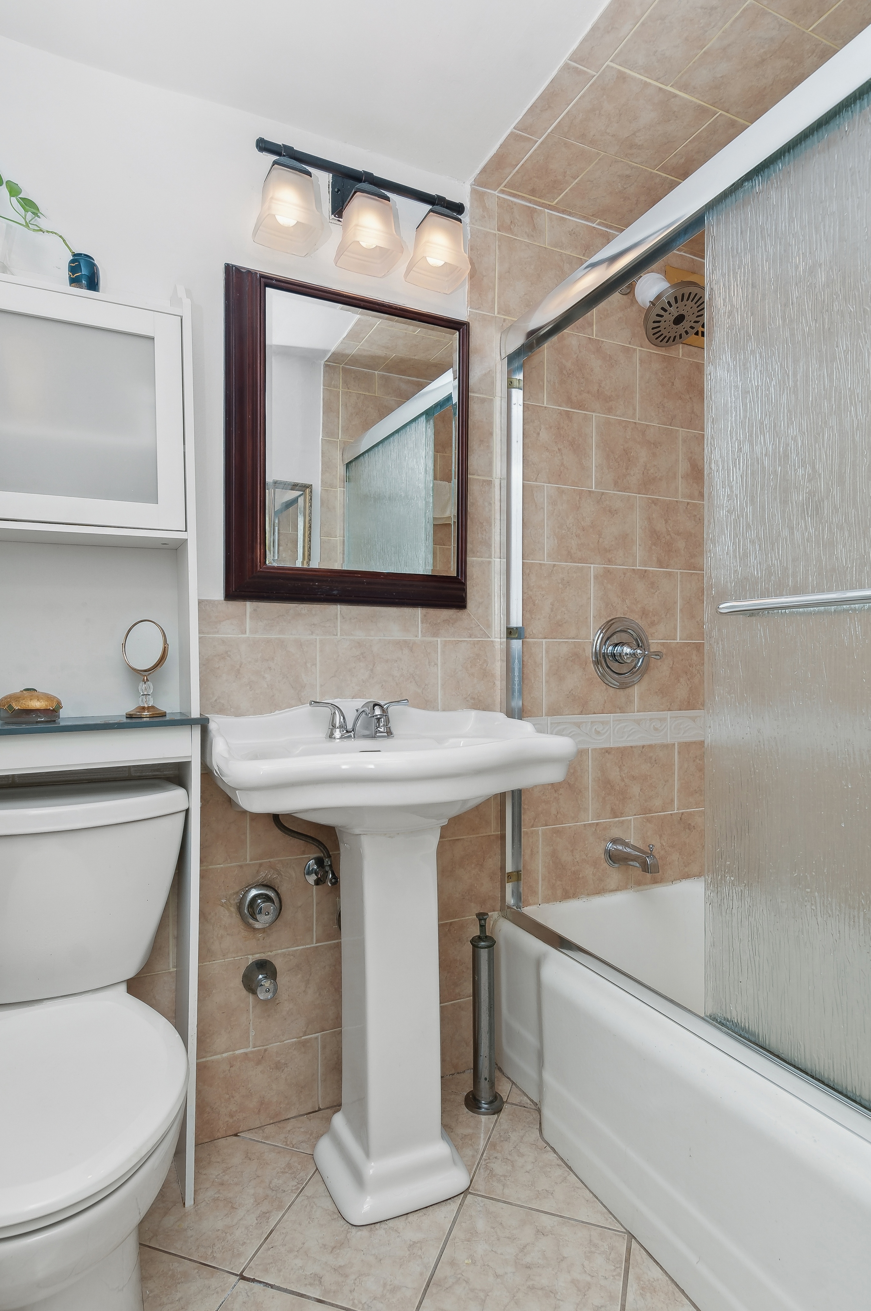408 West 34th Street, Unit 1F Manhattan, NY 10001 - Photo 10 of 13 a bathroom with a sink a toilet and shower